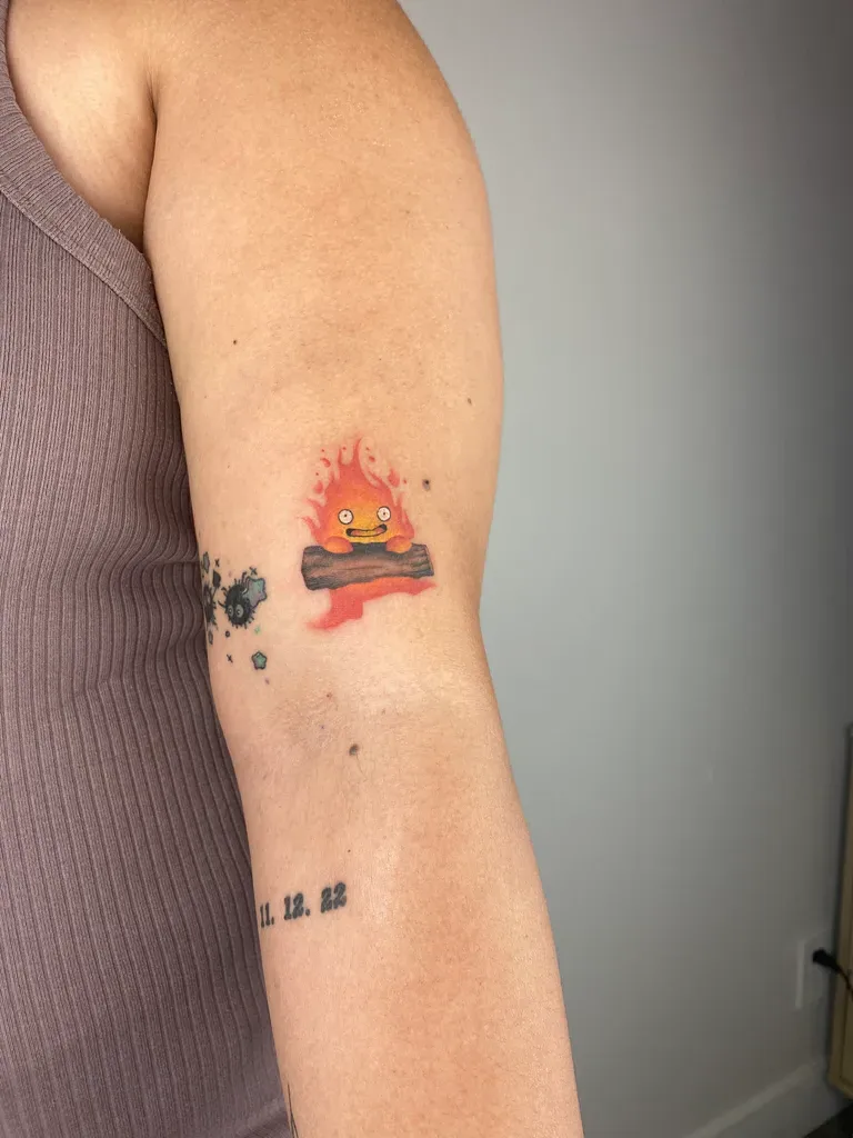 Fire demon tattoo design, anime style, on the bicep, on a log with a date below it, with black splatters and red and orange flames