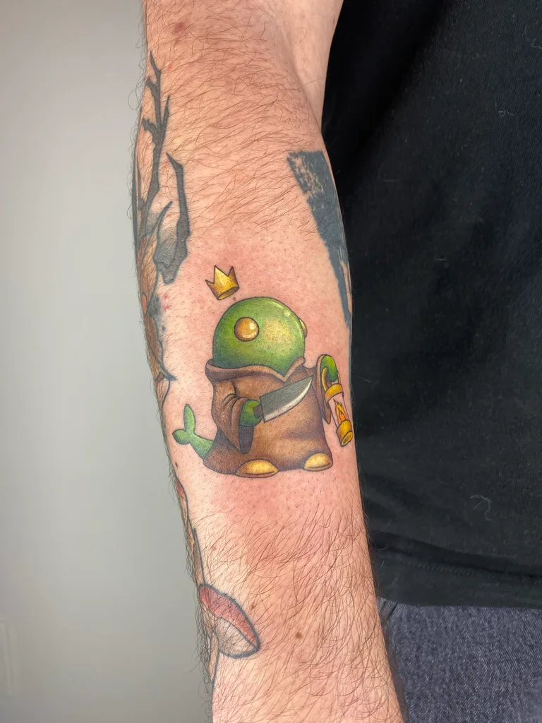 Green creature tattoo design for men, anime style, on the forearm, a small green creature in a brown robe with a tiny crown above its head, in full color