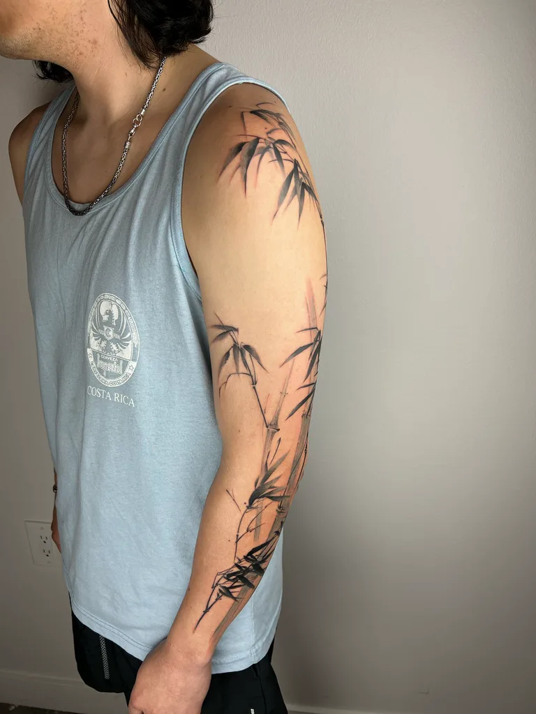Bamboo tattoo design for men, Chinese brush painting style, on the full sleeve, ink-brush bamboo stalks and leaves sweeping from the shoulder down the outer arm