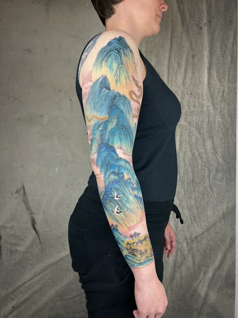 Blue mountains tattoo design for women, Chinese brush painting style, on the full sleeve, blue and green shan shui mountain landscape with mist covering the whole arm