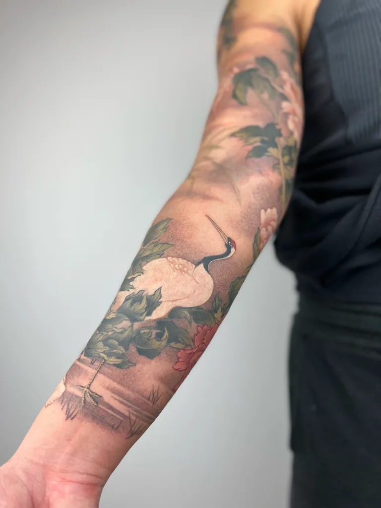 Crane peonies tattoo design for women, Chinese brush painting style, on the full sleeve, red-crowned crane standing among muted peonies along the forearm
