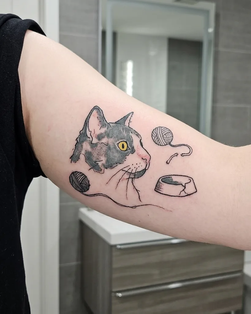 Cat tattoo design, ignorant style, on the bicep, in grey and white with yellow eyes, with two balls of yarn and a cracked food bowl