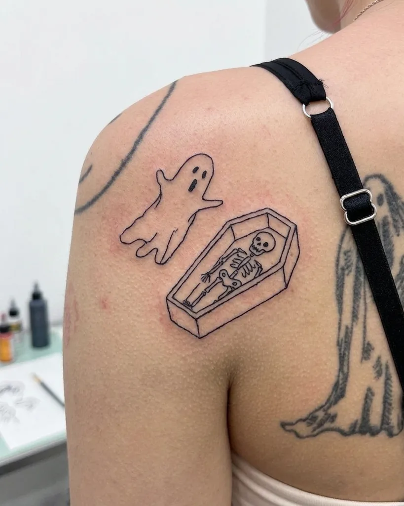 Ghost coffin tattoo design for women, ignorant style, on the shoulder, with a skeleton in a coffin next to a flying ghost