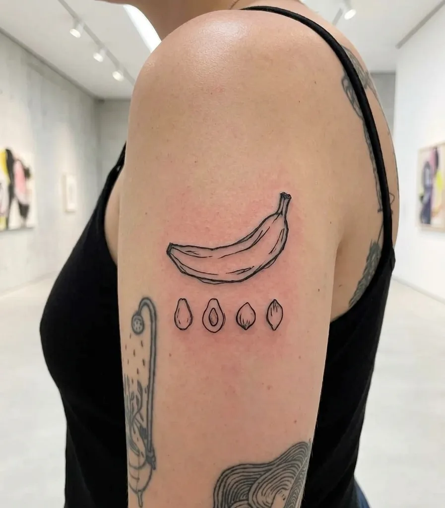 Banana tattoo design for women, ignorant style, on the upper arm, with a line drawing style, accompanied by four small oval shapes below