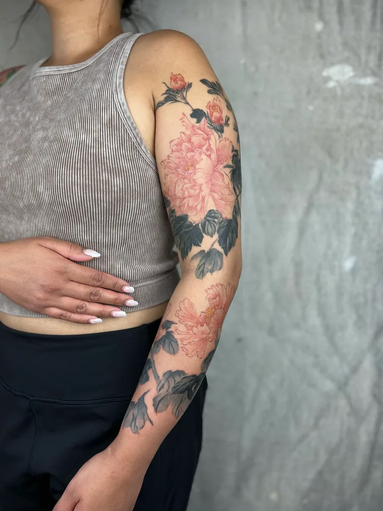 Pink peonies tattoo design for women, illustrative style, on the full sleeve, soft pink peonies with dark leaves flowing from shoulder to forearm