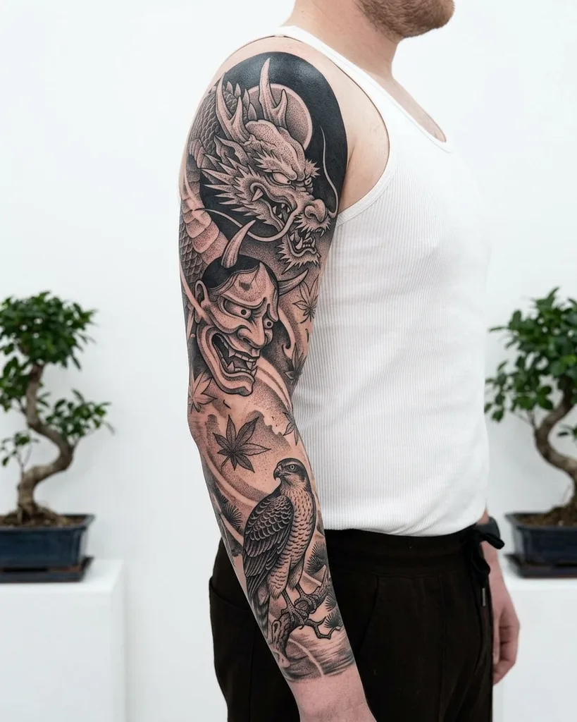 Dragon tattoo design for men, Japanese style, on the full sleeve, with a hannya mask, a bird, and maple leaves in black and grey