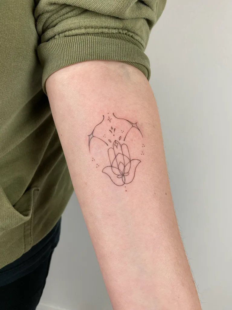 Hamsa moon tattoo design for women, minimalist style, on the forearm, hamsa hand under a crescent moon with small stars, single-line style